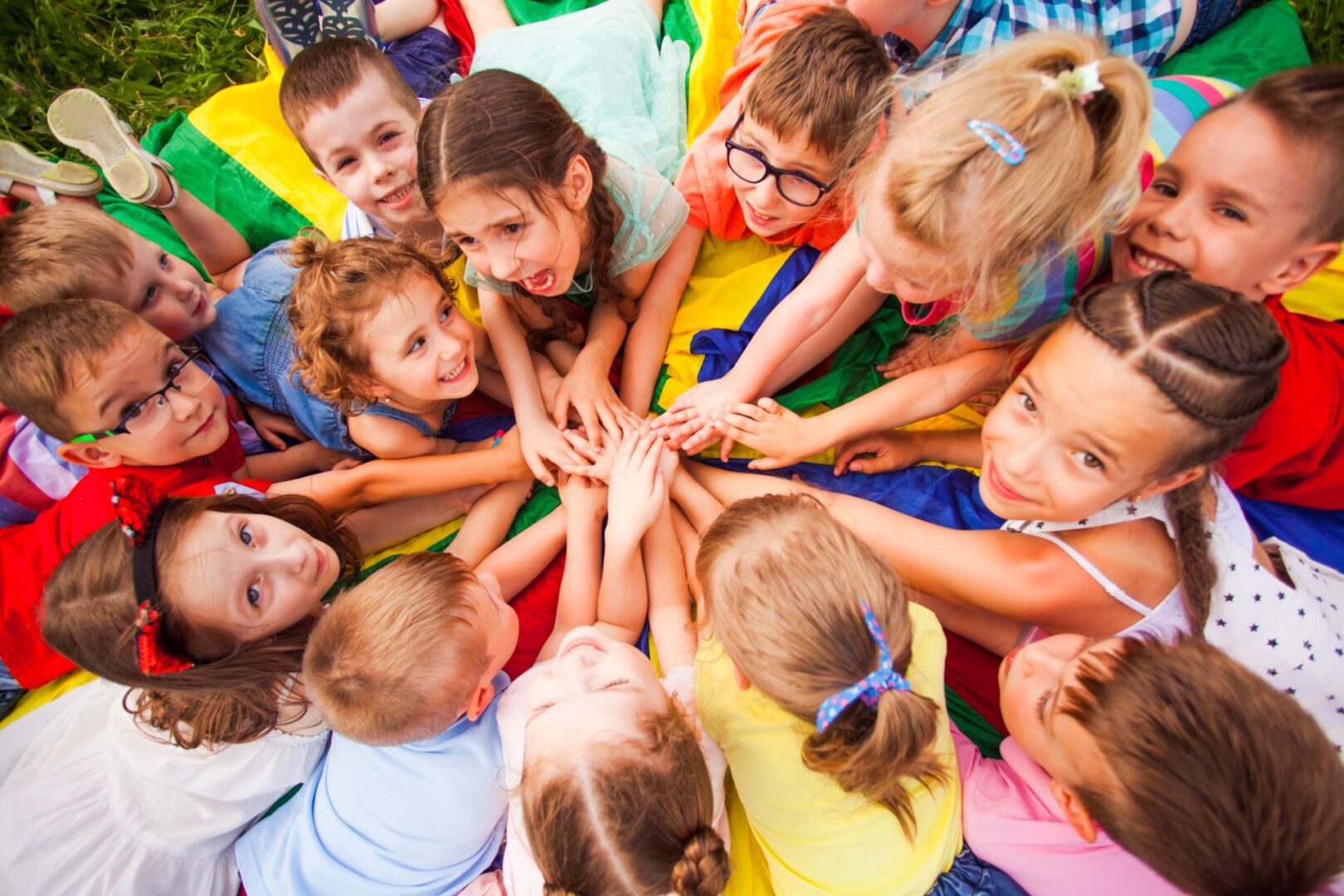 A group of children holding hands in the middle of a circle.