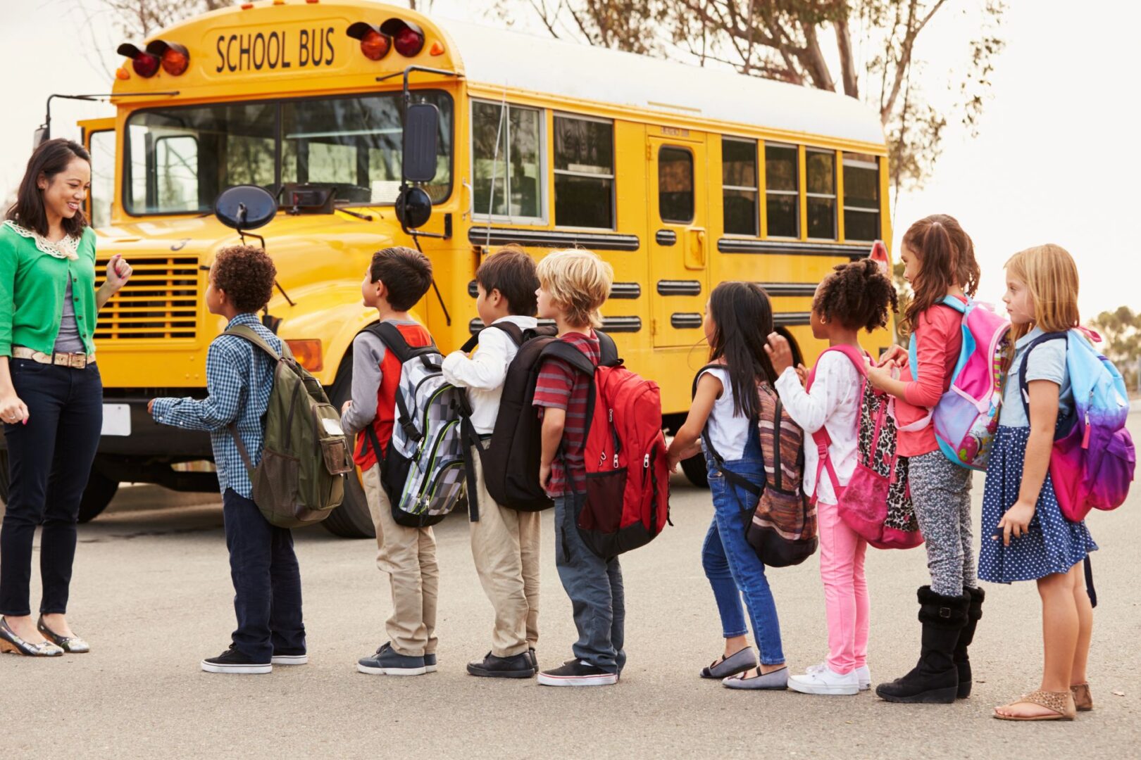 A group of children standing in front of a school bus.