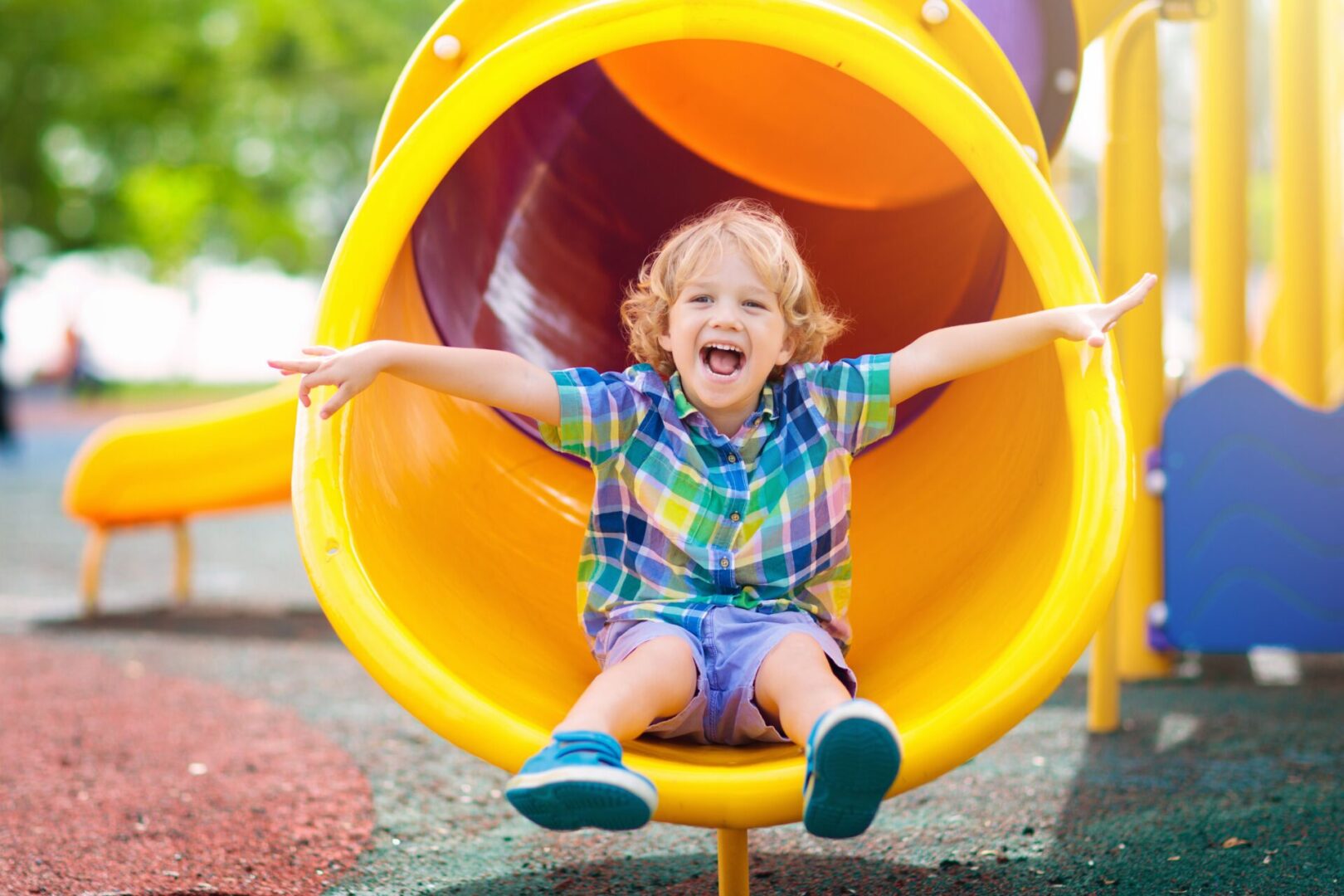 A little boy sitting in the middle of a yellow tube.