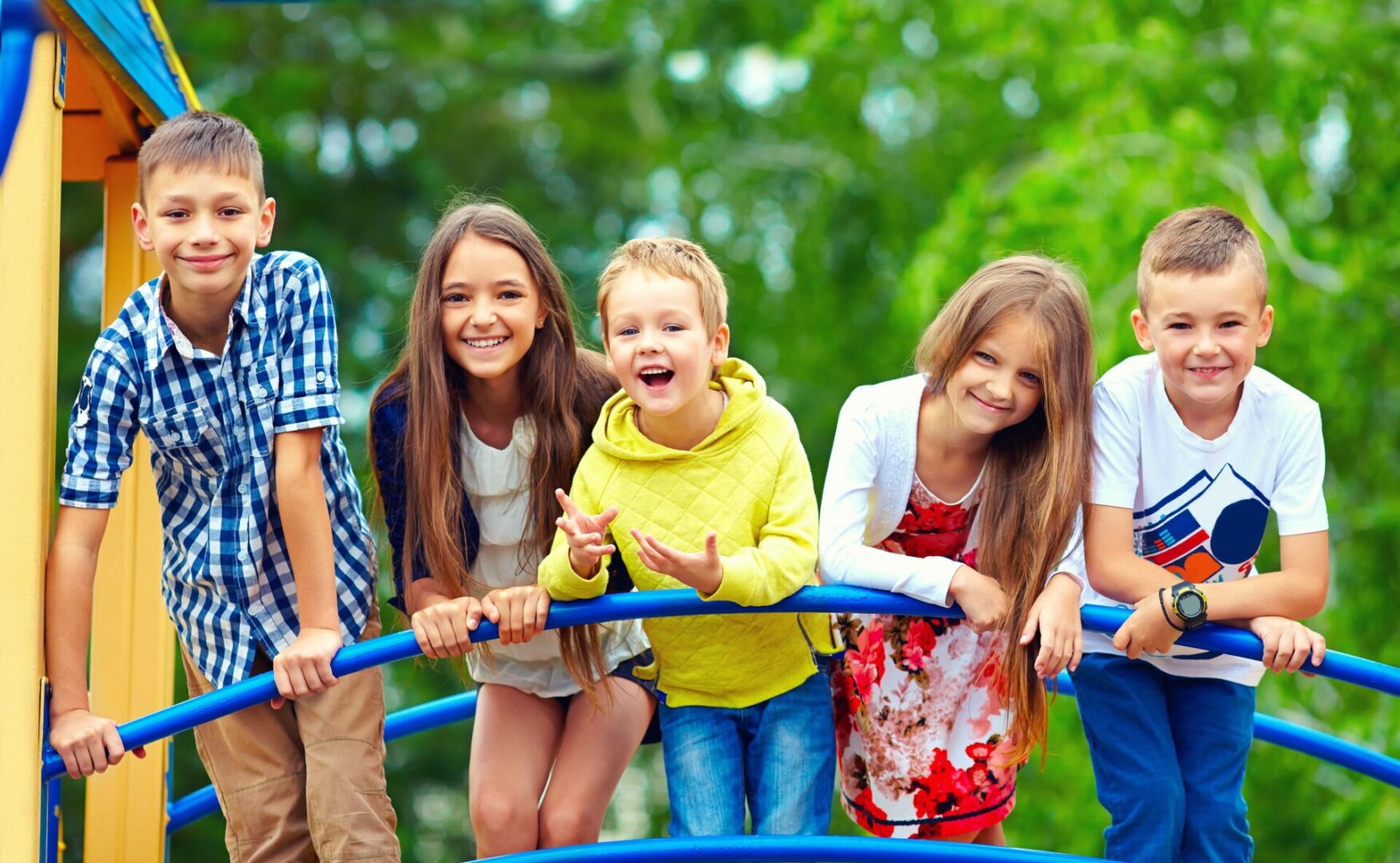 A group of kids on a playground swing set.